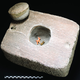 The stone container with llama figurine and gold bracelet inside.